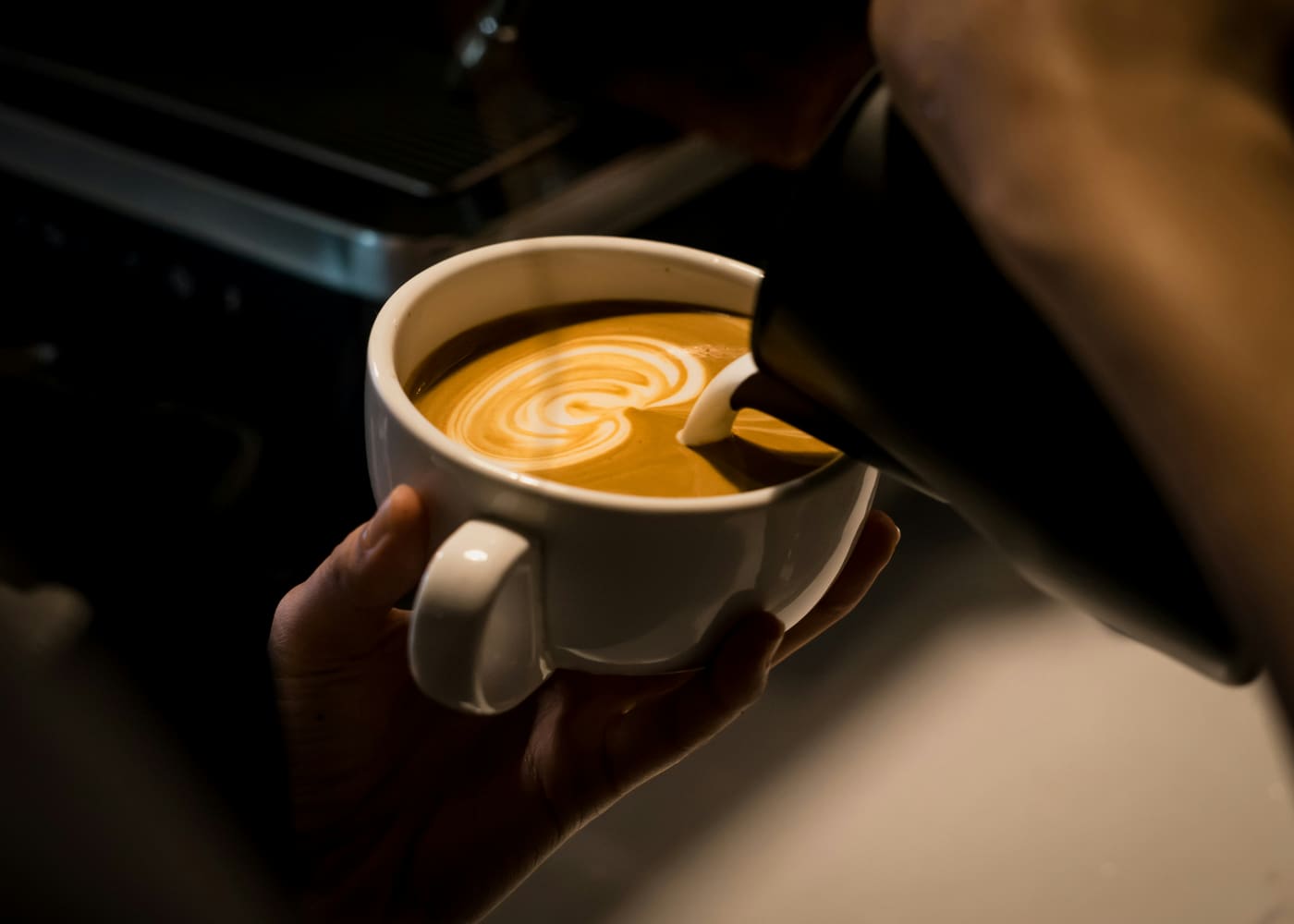 Barista sirviendo un latte con arte en la espuma